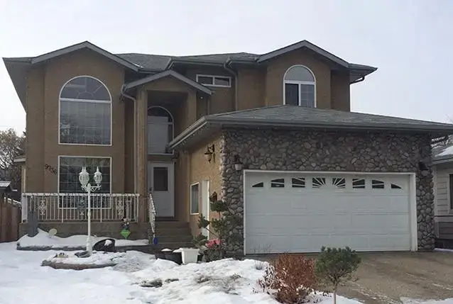 brown house with stone around garage