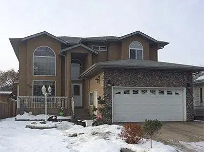 Exterior house painting project in Edmonton featuring a freshly painted two-storey home.